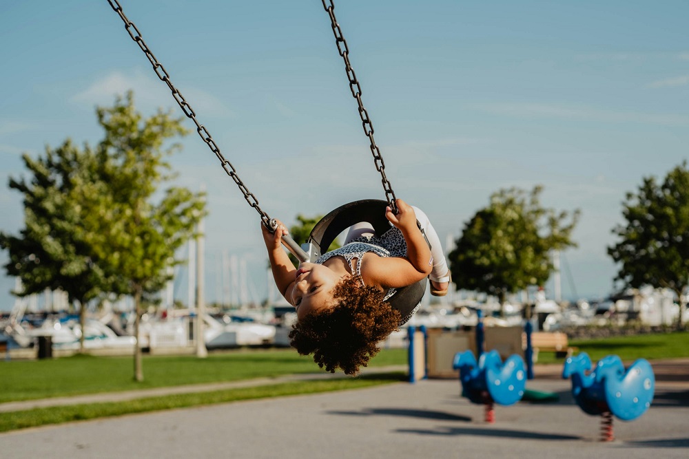 A child playing on a swing in a park